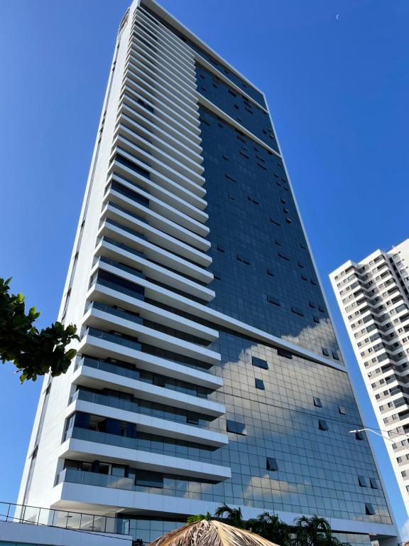 un edificio alto con un cielo azul en el fondo en Barra Home stay 22 andar en Recife