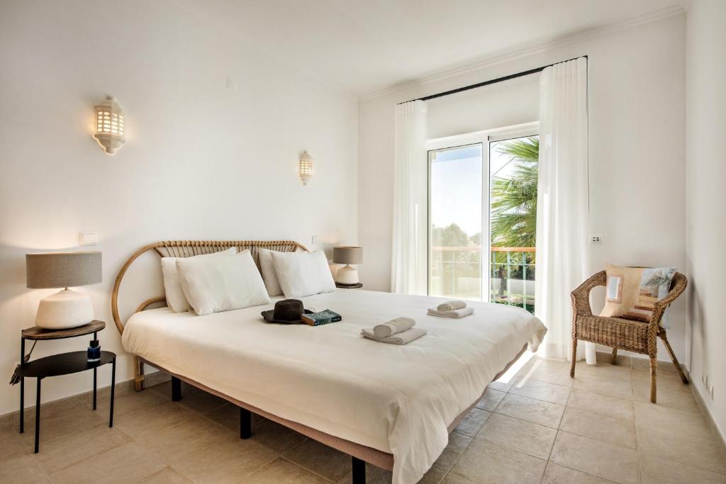 - une chambre avec un grand lit blanc et une fenêtre dans l'établissement Modern and Spacious Two Bedroom Apartment, à Carvoeiro