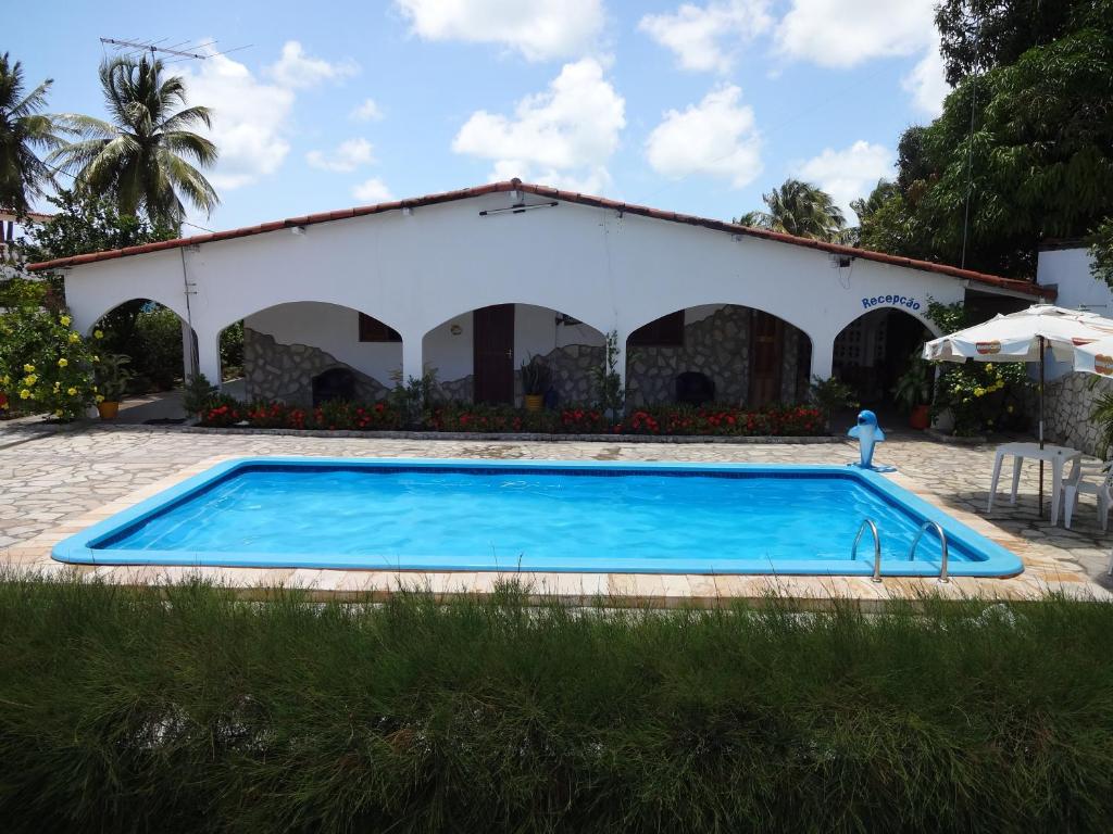 a swimming pool in front of a building at Pousada Dos Arcos in Jacumã