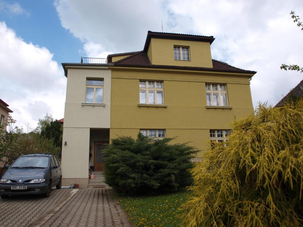 ein gelbes Haus mit einem davor geparkt in der Unterkunft Dalimilka in Leitmeritz