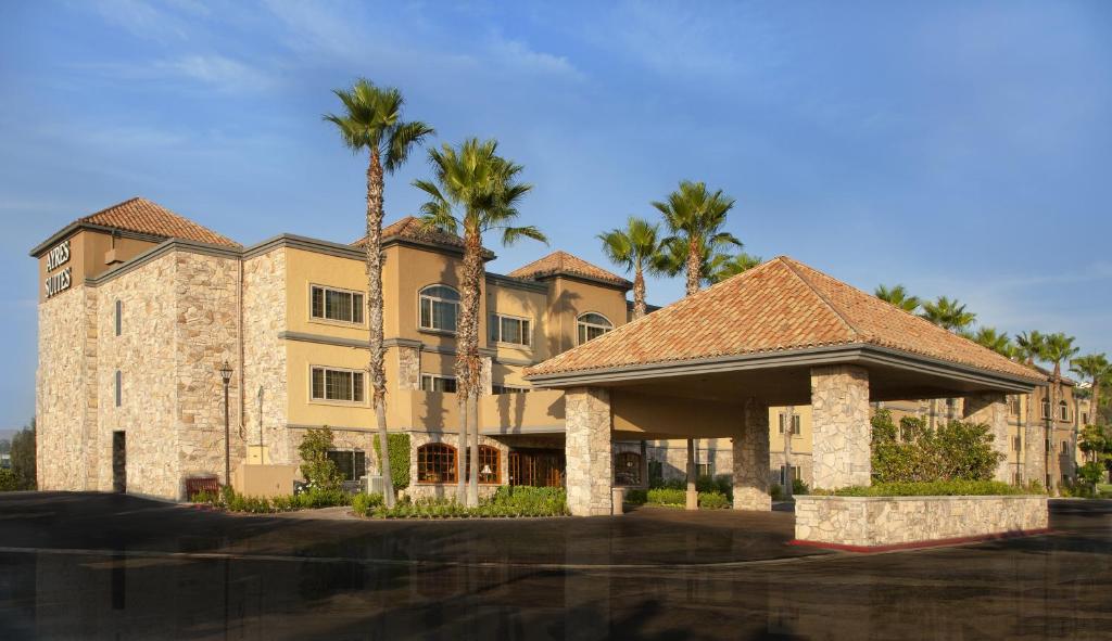 a large building with palm trees in front of it at Ayres Suites Diamond Bar in Diamond Bar