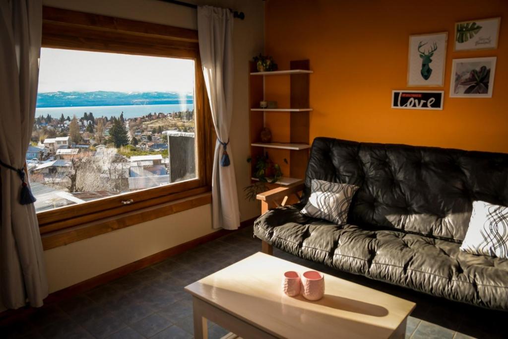 - un salon avec un canapé et une grande fenêtre dans l'établissement Espacio Pueblo, à San Carlos de Bariloche