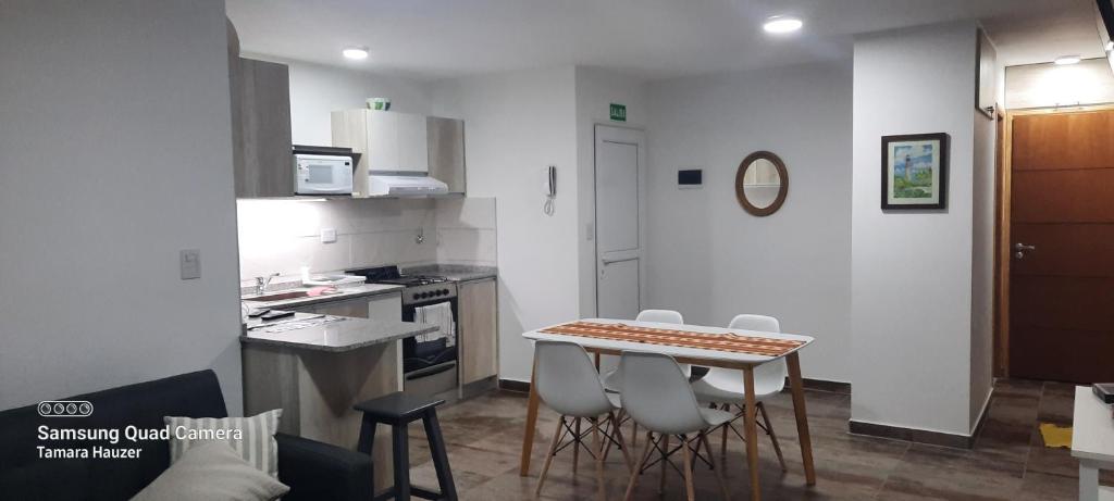 uma cozinha com mesa e cadeiras num quarto em Lalúan departamento temporario em Ushuaia