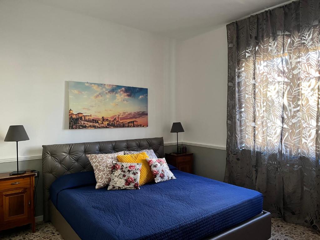 una camera da letto con un letto con lenzuola blu e una finestra di Casa di TAta 2 a Trezzo sullʼAdda