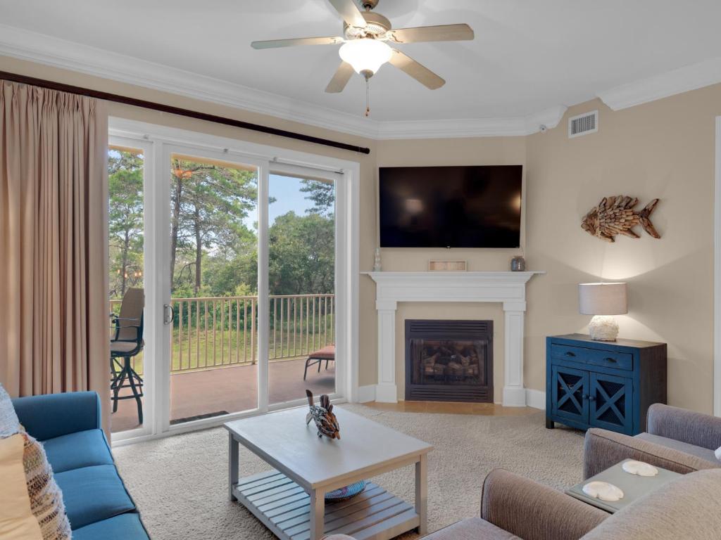 Una sala de estar con chimenea y televisión. en Sanctuary at Redfish 1119 by Newman-Dailey, en Santa Rosa Beach