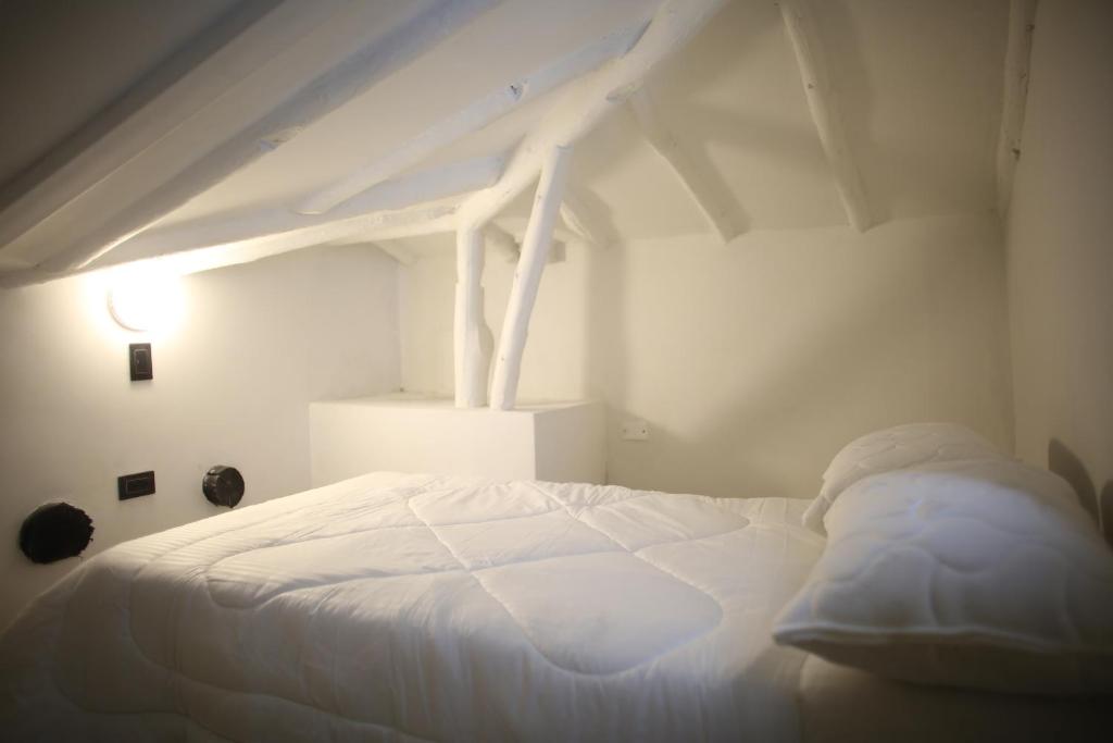 a white bed in a white room with a white ceiling at Conjunto San Fernando in Bogotá