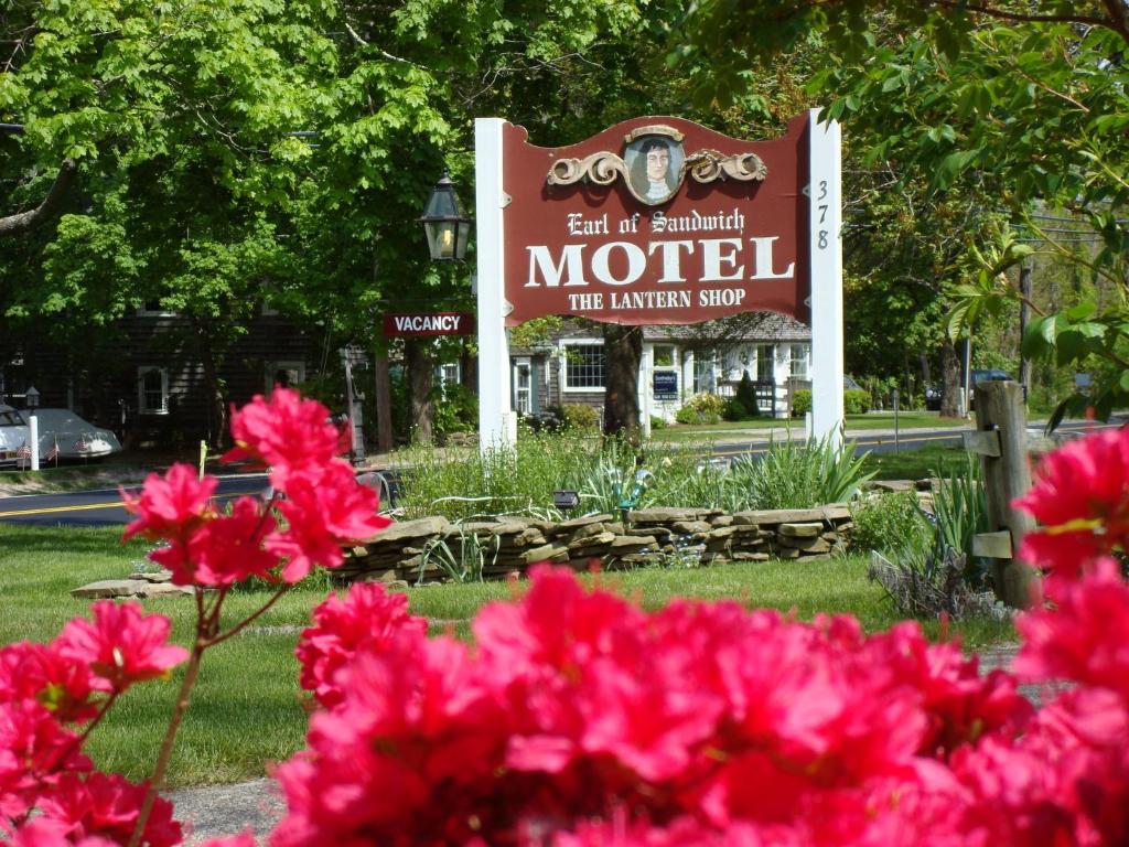 a sign for a motel with pink flowers in the foreground at The Earl of Sandwich Motel in East Sandwich