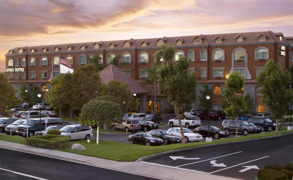 a rendering of a building with cars parked in a parking lot at Ayres Suites Yorba Linda/Anaheim Hills in Anaheim