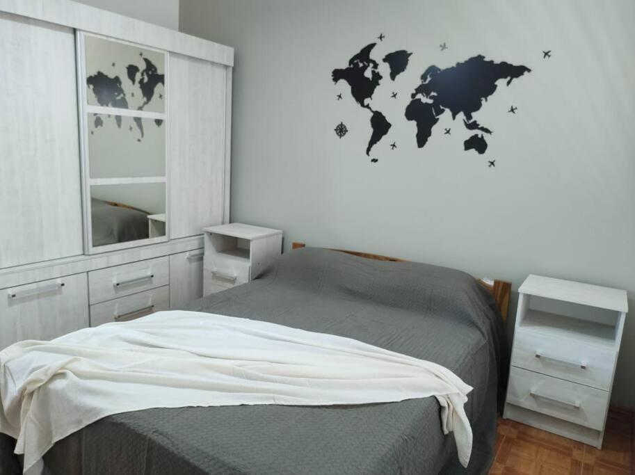1 dormitorio con 1 cama con mapa en la pared en CASA MUY COMODA A METROS DEL SANTUARIO Y ECOPARQUE en San Nicolás de los Arroyos