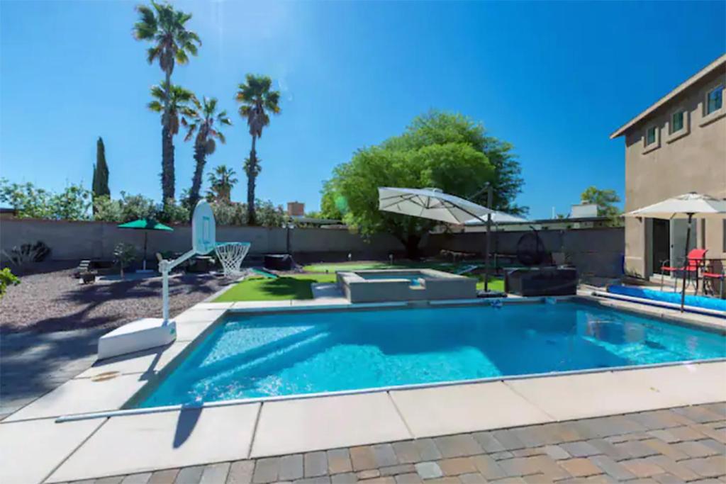 a swimming pool in a backyard with palm trees at Family Fun Vacation, Heated Pool, Gameroom, Sauna in Tucson
