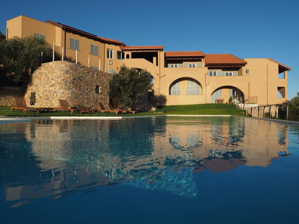 a large house with a large body of water at Agriturismo "I Castellari" in Pietra Ligure