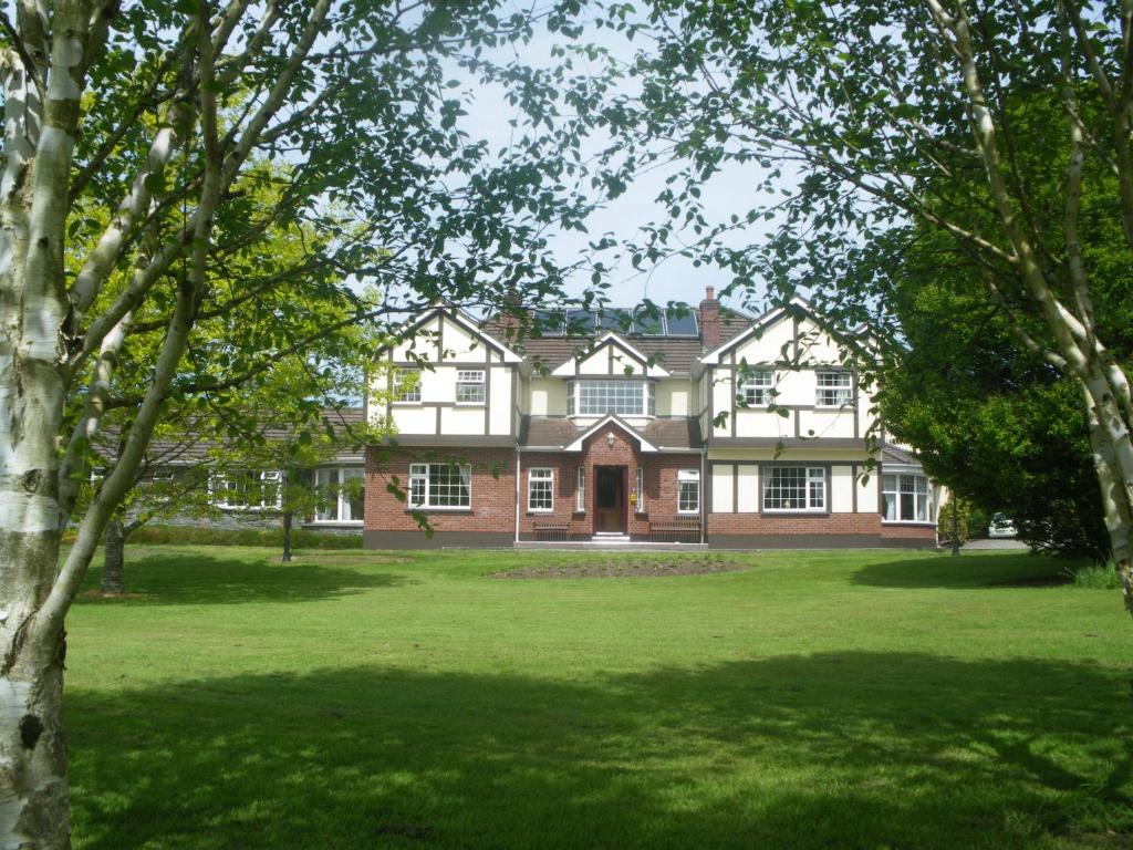 a large house with a green lawn in front of it at Redwood in Killarney