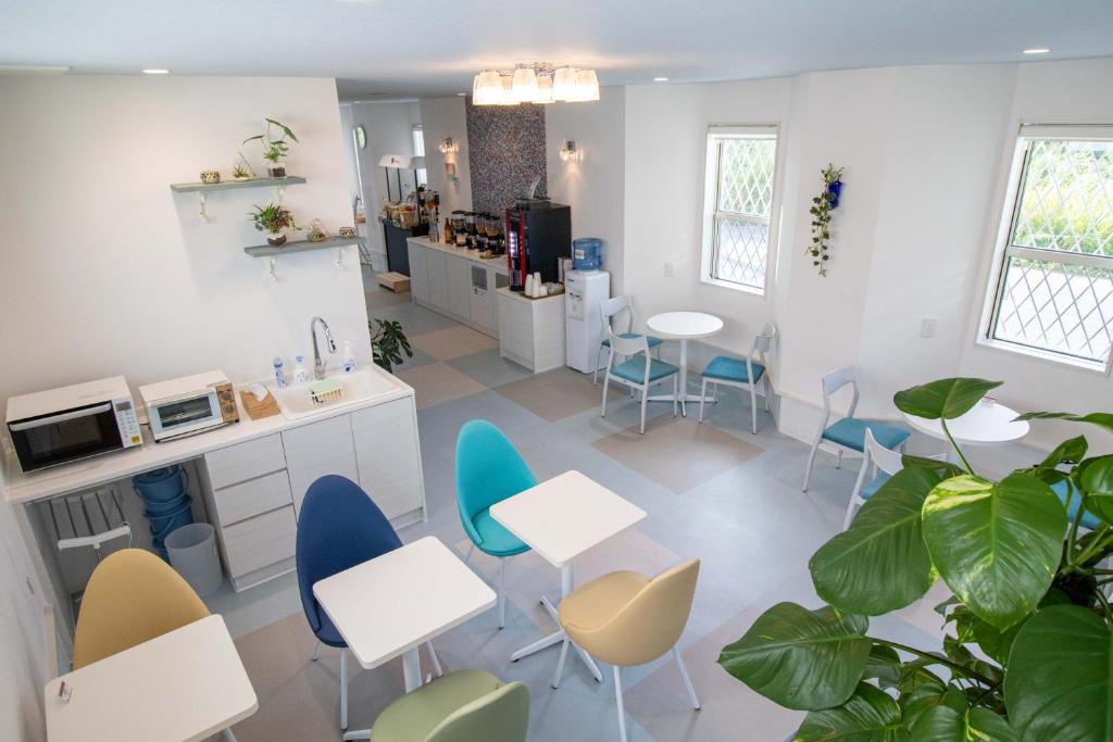 a room with tables and chairs and a kitchen at Hotel Santa Barbara Miyakojima Resort in Miyako-jima