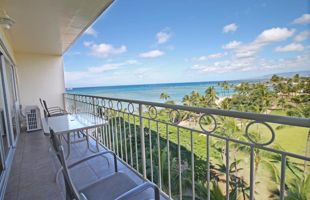 a balcony with a table and chairs and the ocean at Castle Waikīkī Shore in Honolulu