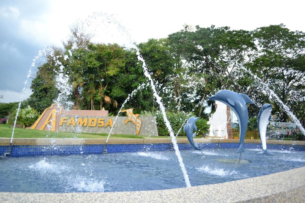 a fountain with dolphins in the water in front of a park at A'Famosa Condo D'Savoy, Slumber Family Homestay Mslim guest only in Kampong Pulau Sebang