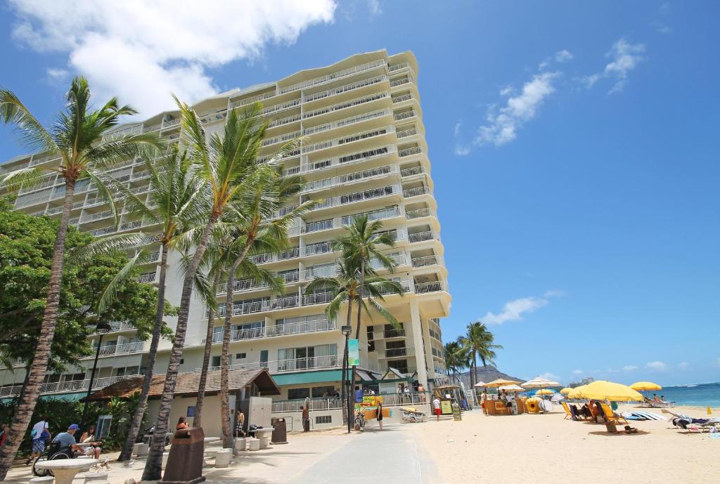 duży budynek na plaży z palmami w obiekcie Castle Waikīkī Shores w mieście Honolulu