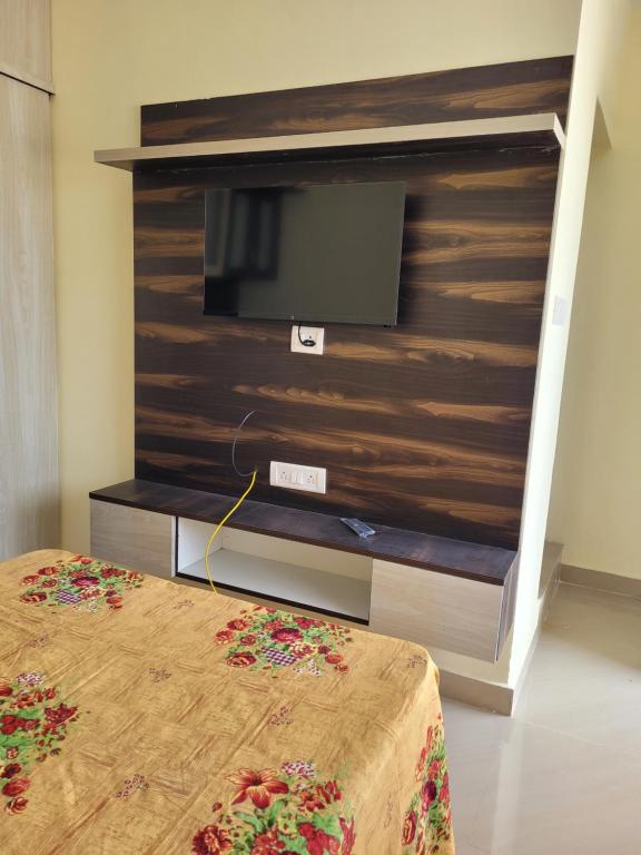 a bedroom with a tv on a wooden wall at RV backpackers in Bangalore