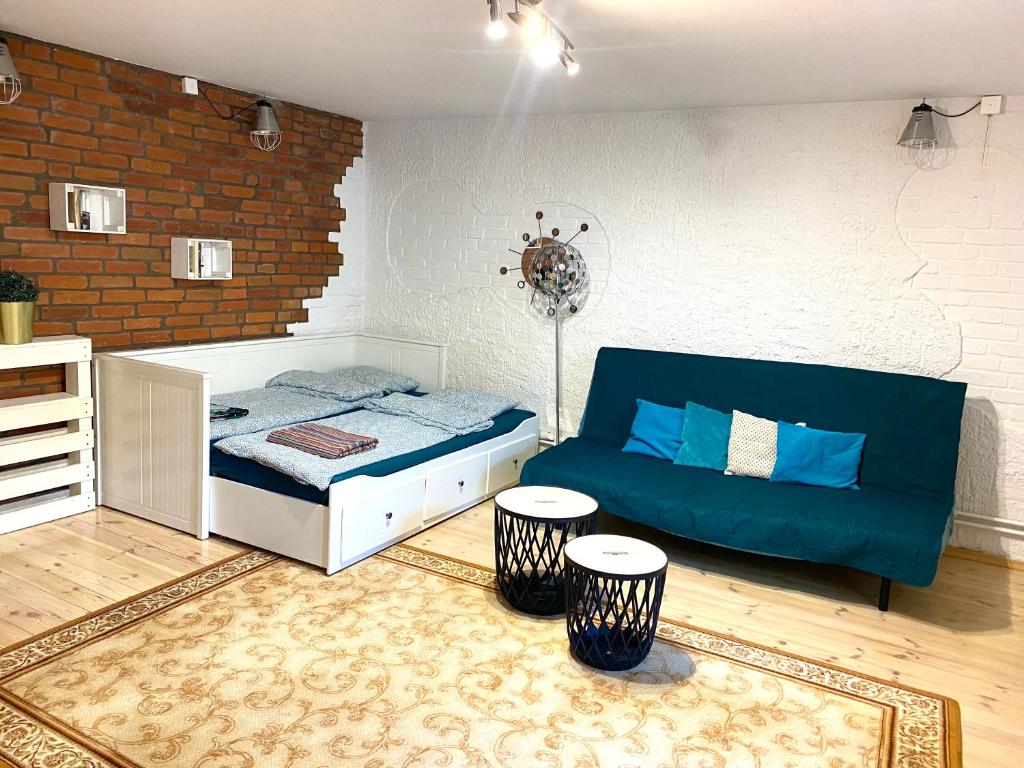 - un salon avec un canapé et un lit dans l'établissement Suterena w centrum Mrągowa, à Mrągowo