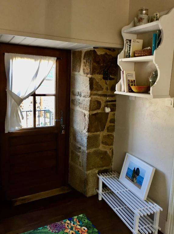 a room with a door and a picture on a bench at Gîte Maison Maitri in Forgès