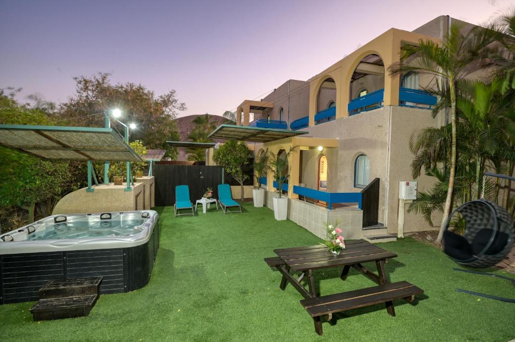 un patio trasero de una casa con bañera de hidromasaje en Club In Eilat Resort - Executive Deluxe Villa With Jacuzzi, Terrace & Parking en Eilat