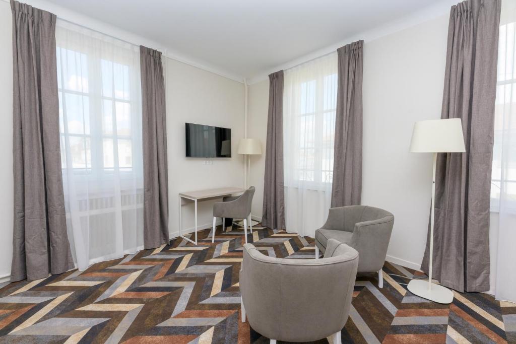 Televízia a/alebo spoločenská miestnosť v ubytovaní Logis HOTEL DU PARC