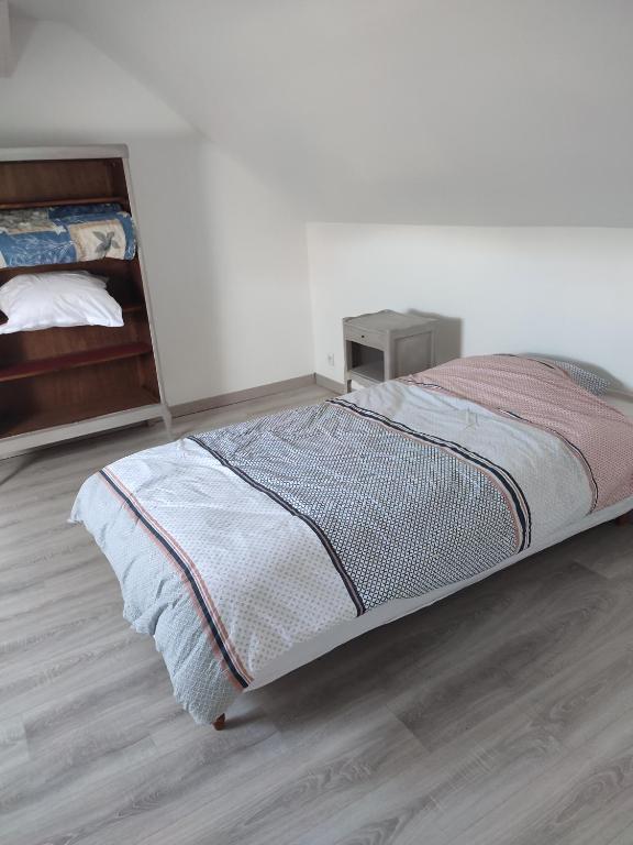 a bedroom with a bed and a wooden floor at La maison fleurie 2 in Sainte-Geneviève-lès-Gasny