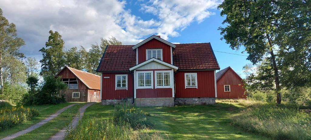 a red house in the middle of a field at Björkbacken Stuga in Markaryd