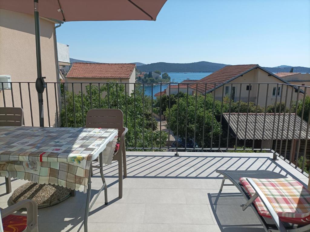 een patio met een tafel en stoelen op een balkon bij Spacious 2-bedroom apartment with terrace sea view in Zaboric