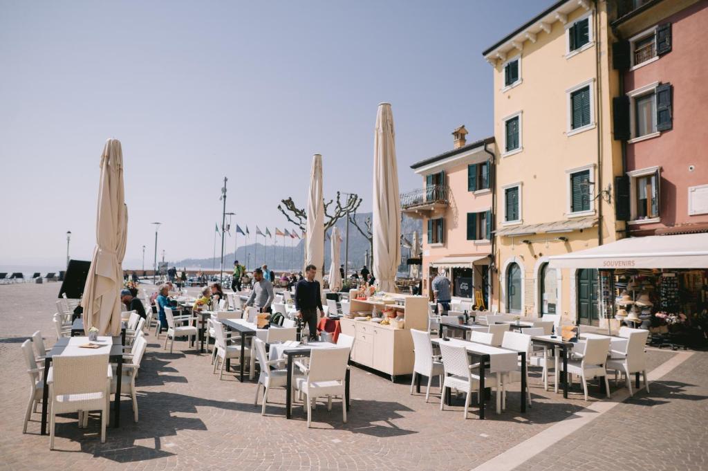 a group of people sitting at tables and chairs at Casa Cavour in Garda