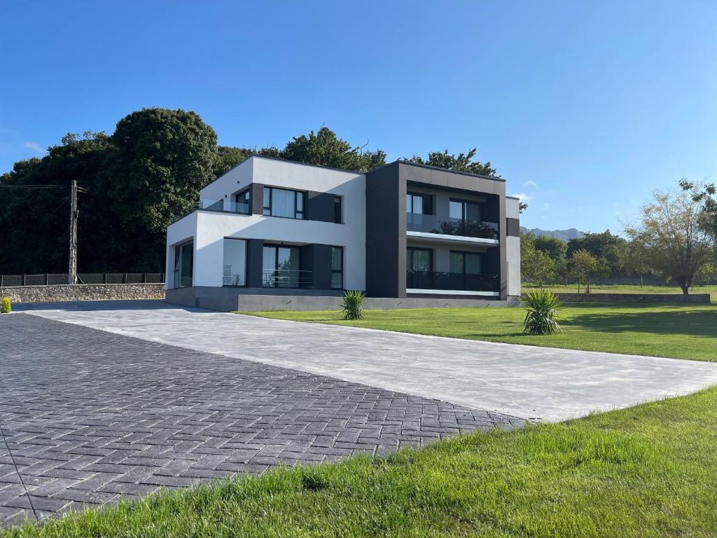 a modern house with a driveway at APARTAMENTOS TURÍSTICOS EL RINCONÍN in Llanes