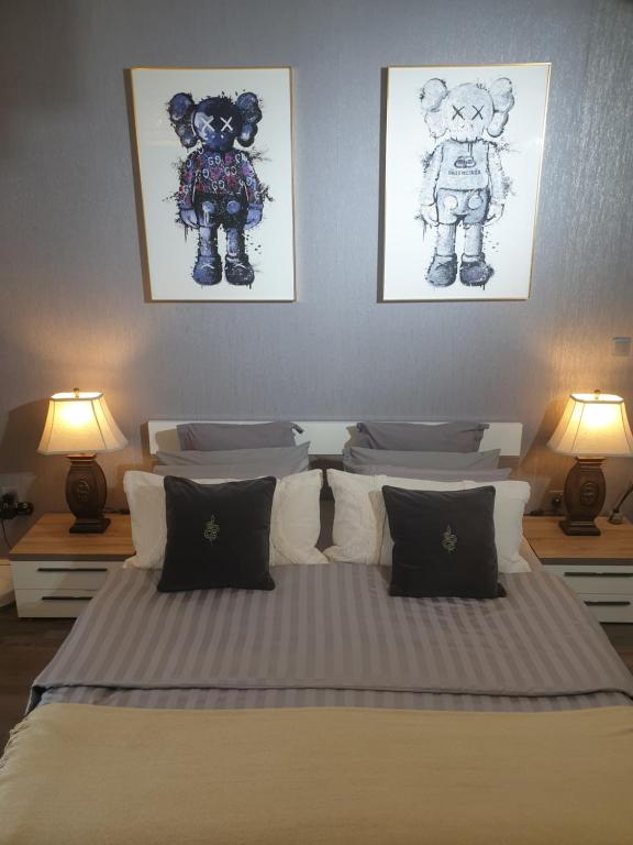 - une chambre avec un lit et 2 photos sur le mur dans l'établissement Melsky Apartment Dubai, à Dubaï