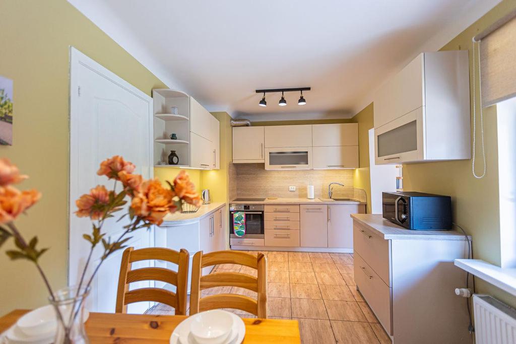 uma cozinha com armários brancos e uma mesa e cadeiras em Schneider hause em Jūrmala