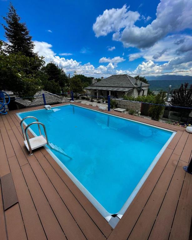 a swimming pool on a deck with a chair next to it at Archontiko Zarkada in Monodendri