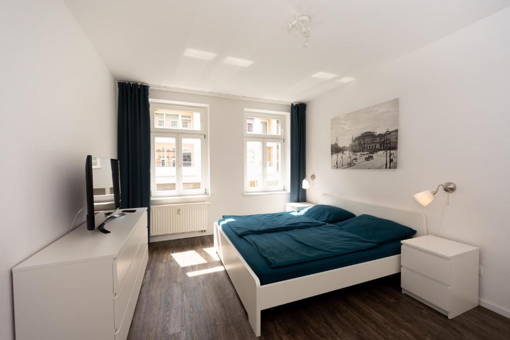 een slaapkamer met een bed en een televisie. bij L.E. Home in Leipzig