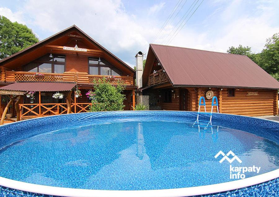 a large swimming pool in front of a house at Family Green in Sasovka