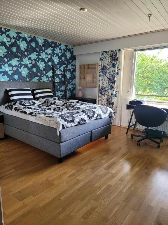 1 dormitorio con cama, escritorio y ventana en Niittyvilla Apartments, en Jämsä