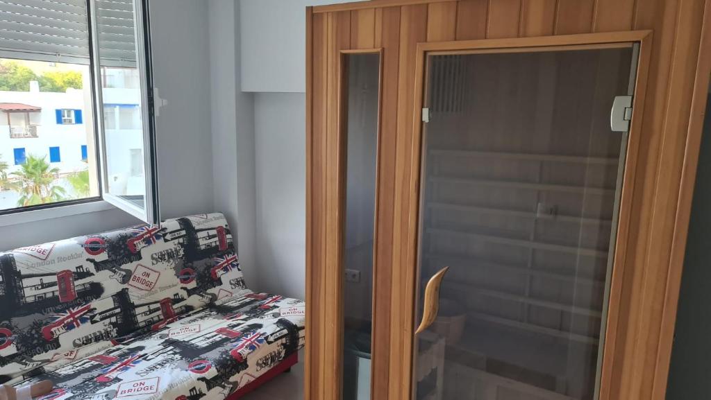 a bedroom with a bed and a glass door at TRIPLEX DE LUJO EN MOJACAR in Mojácar