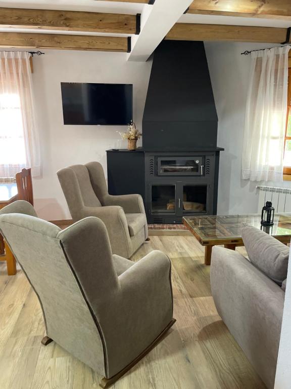 uma sala de estar com duas cadeiras e uma lareira em Vivienda Turística Rural Casa Irene em Segura de la Sierra