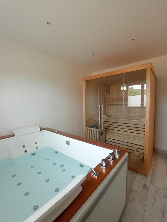 une salle de bain avec une grande baignoire dans une chambre dans l'établissement Gîte Au fil de Drancourt, à Drancourt