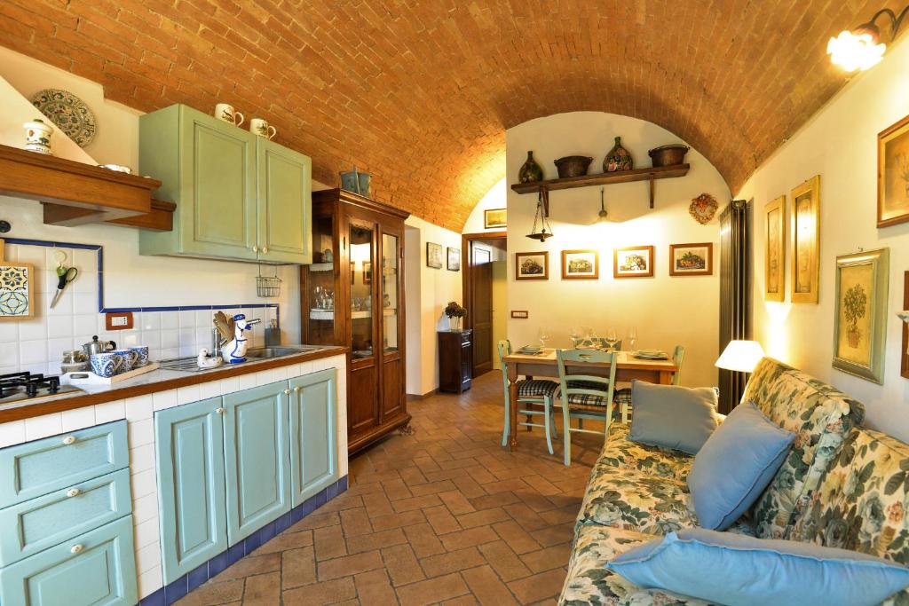 a kitchen and living room with a couch and a table at Appartamento Vecchio Mulino in Isola d'Arbia