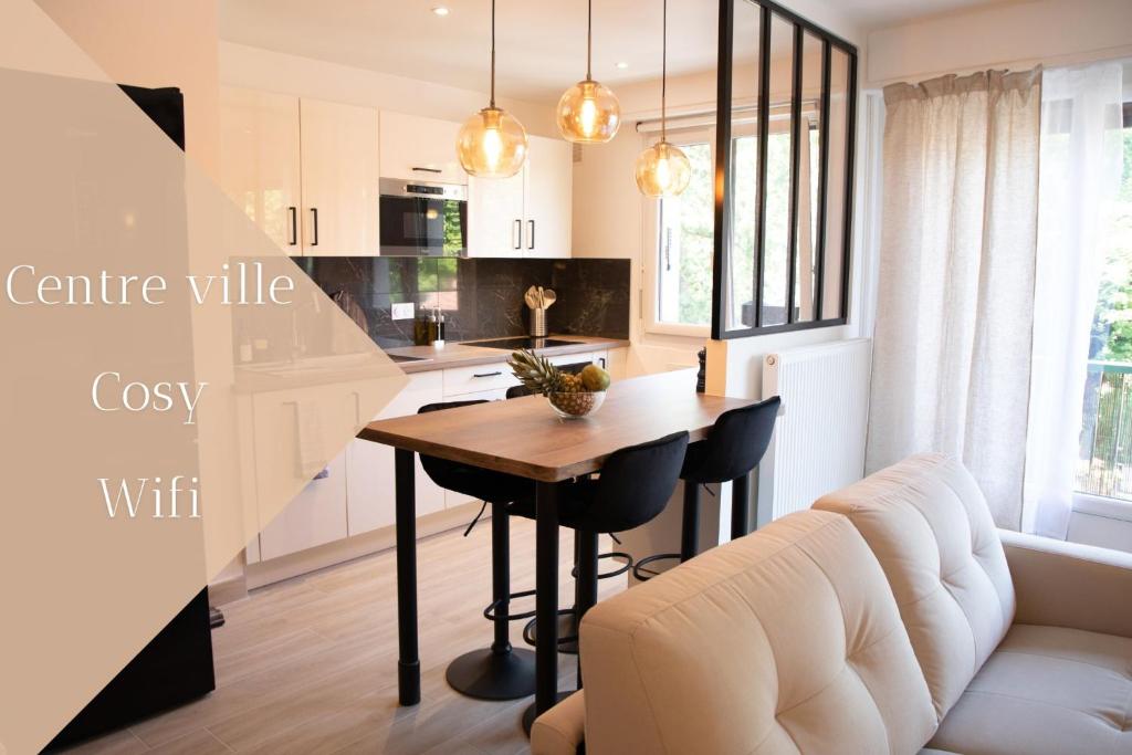 a kitchen and living room with a table and a couch at L'ÉLÉGANCE DU VIGNY in Divonne-les-Bains