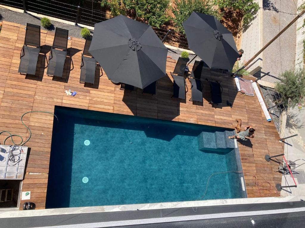einen Blick über einen Pool mit Sonnenschirmen in der Unterkunft Apartments Sky in Rijeka