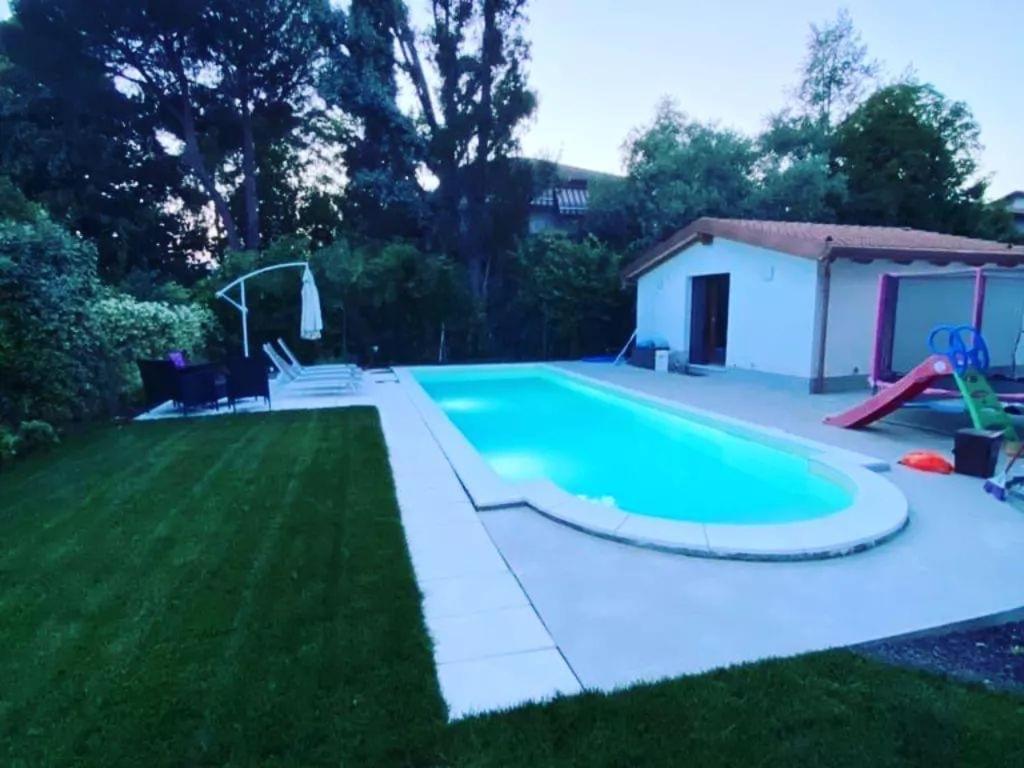 a swimming pool in the backyard of a house at Appartamento con giardino, La Casa di G&G in Marina di Carrara