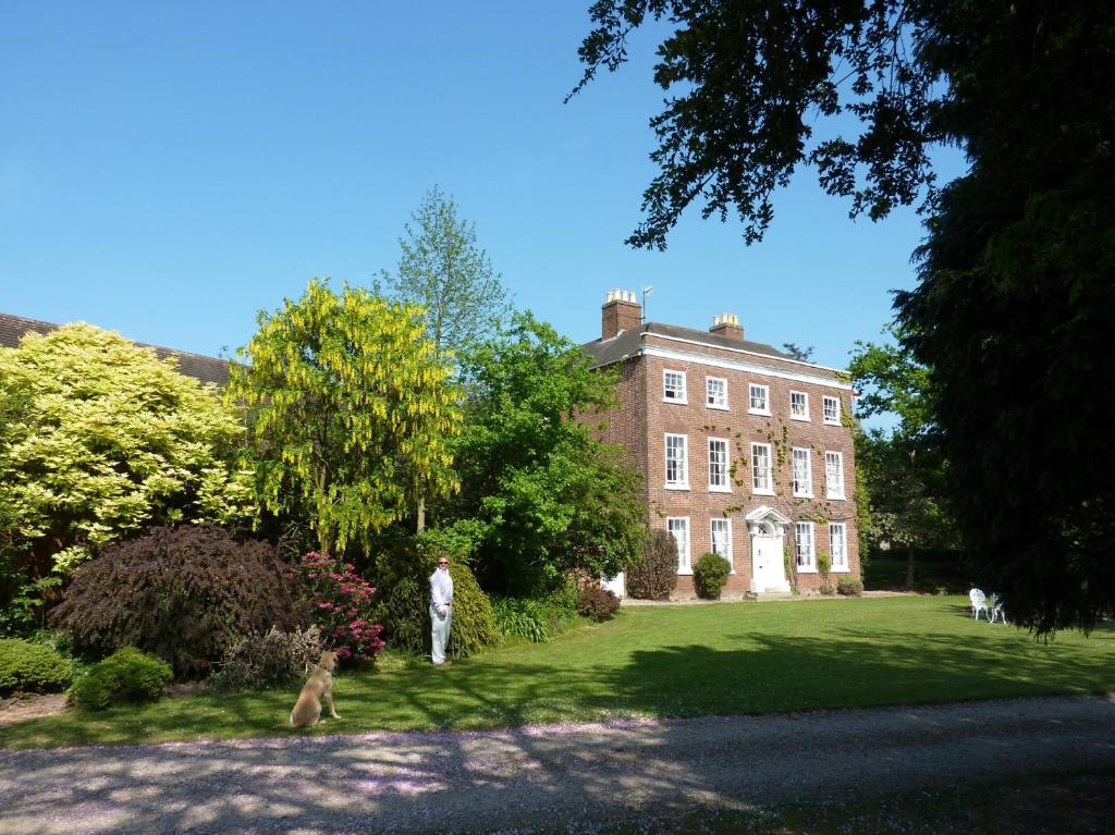 een man die voor een groot stenen huis staat bij Church house 