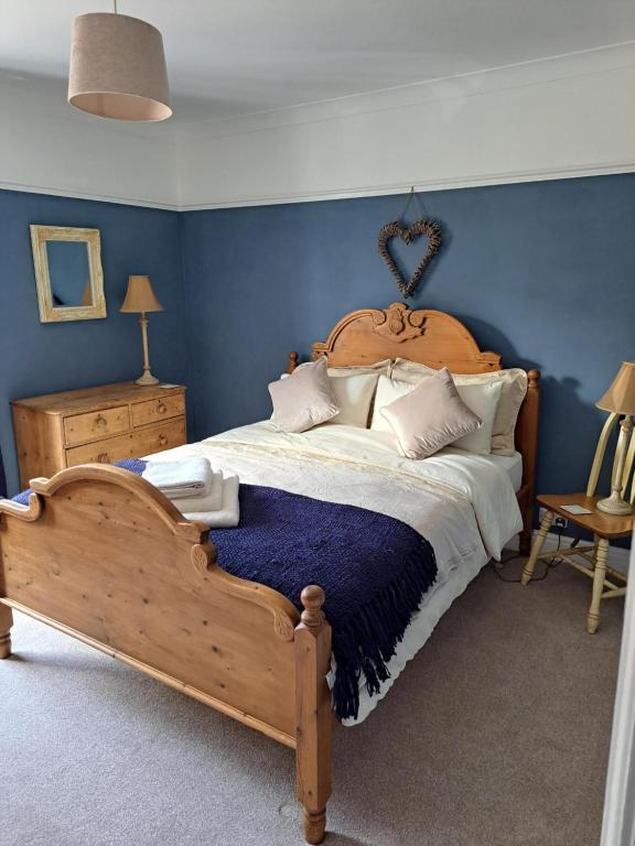 a bedroom with a wooden bed with blue walls at Character Beverley Town House in Beverley