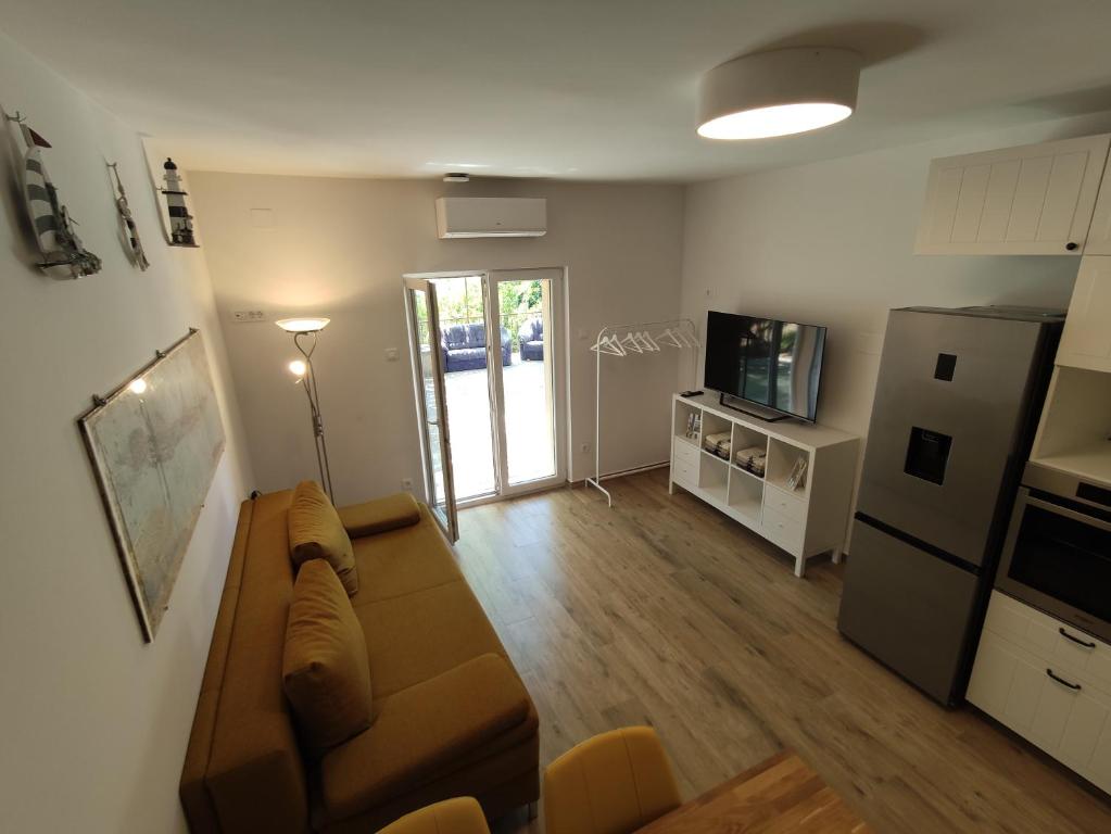 a living room with a couch and a refrigerator at Apartman-studio, Salamunic, Pelinje, Jelsa in Jelsa