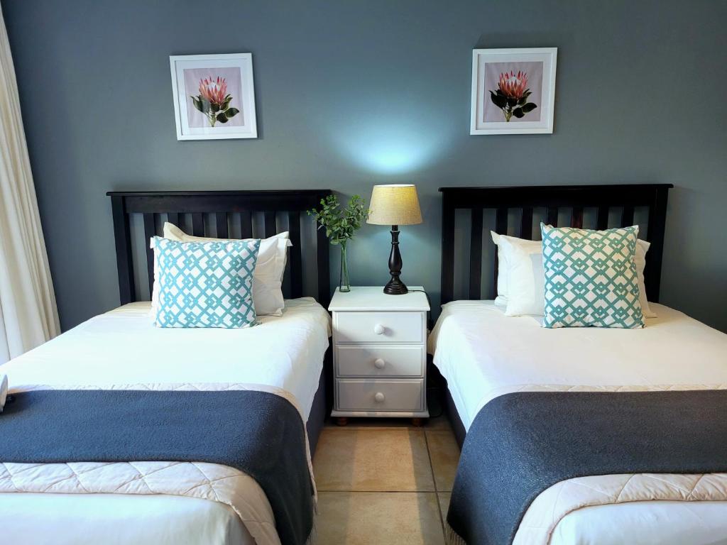 - 2 lits dans une chambre aux murs bleus dans l'établissement Tropical Seaside Suite 8, à East London