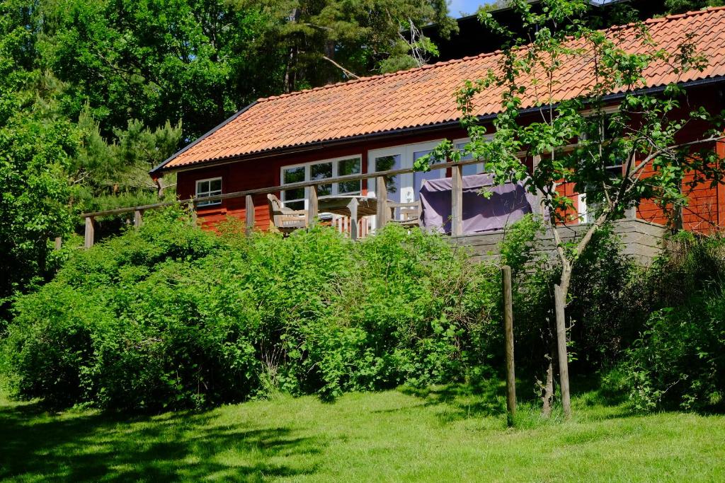 una casa con techo rojo y patio en Fishermans cabin en Myttinge