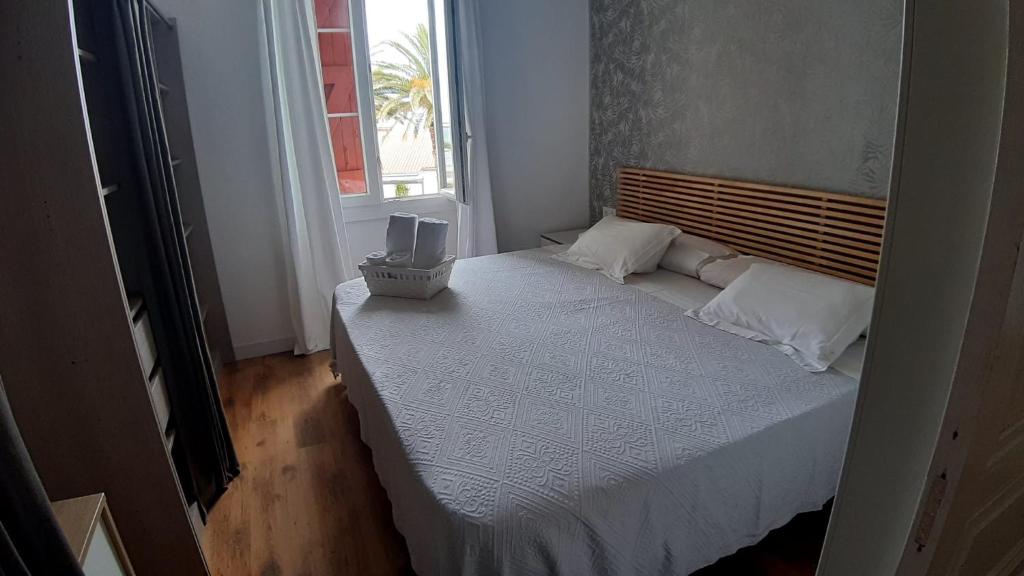 Dormitorio pequeño con cama y ventana en Appartement vue sur l ocean, en Hendaya