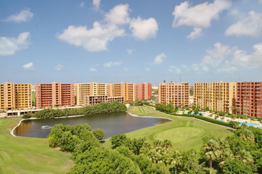 - une vue aérienne sur un complexe avec un lac et des bâtiments dans l'établissement Golf Porto Marina Hotel Apartments Al Alamein, à El Alamein